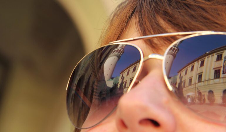 Kobieta ma na twarzy dopasowane okulary przeciwsłoneczne